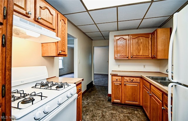 kitchen featuring a drop ceiling and white appliances