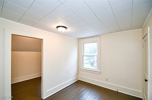 spare room with dark hardwood / wood-style flooring and crown molding