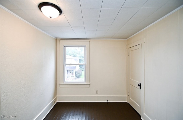 unfurnished room with dark hardwood / wood-style flooring and ornamental molding