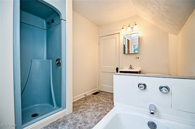 bathroom with vanity, a shower, a textured ceiling, and vaulted ceiling