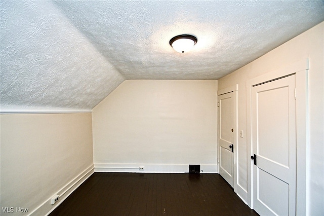 bonus room featuring dark hardwood / wood-style flooring, a textured ceiling, and vaulted ceiling