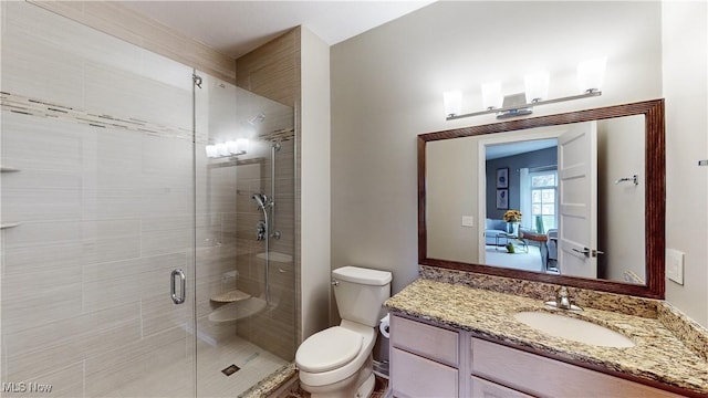 bathroom featuring vanity, a shower with shower door, and toilet