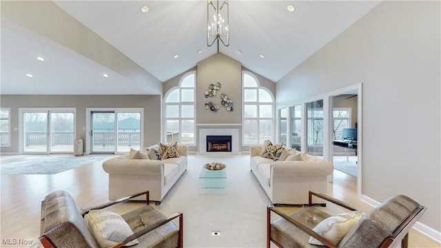 living room featuring a chandelier, high vaulted ceiling, and a wealth of natural light