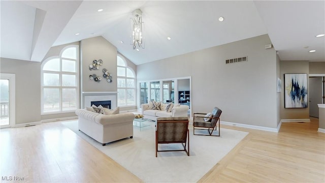 living room featuring a notable chandelier, plenty of natural light, and light hardwood / wood-style flooring