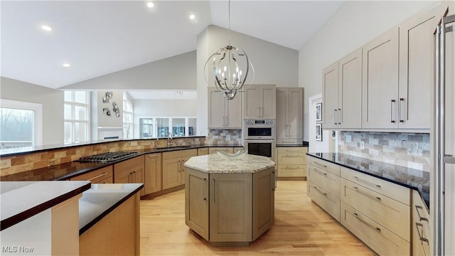 kitchen with appliances with stainless steel finishes, backsplash, sink, pendant lighting, and stone counters