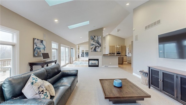 carpeted living room featuring high vaulted ceiling and a skylight