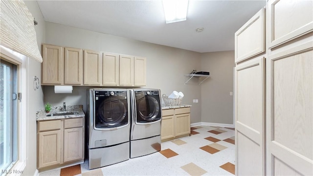 clothes washing area with cabinets, washer and clothes dryer, and sink