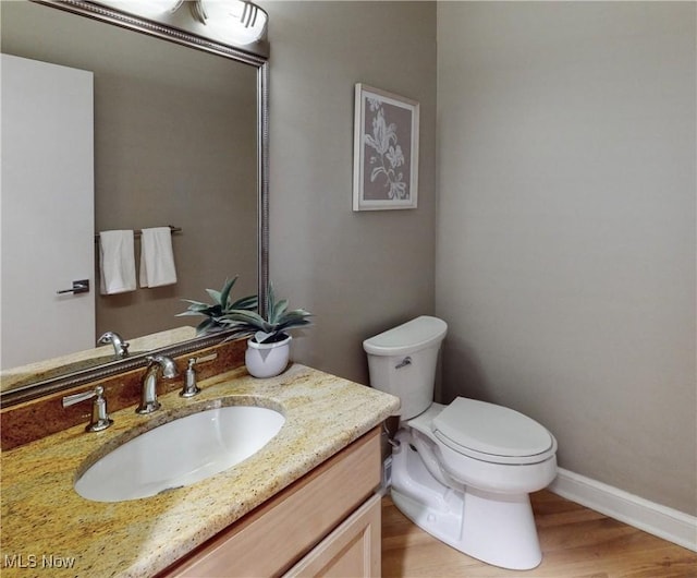 bathroom featuring hardwood / wood-style flooring, vanity, and toilet