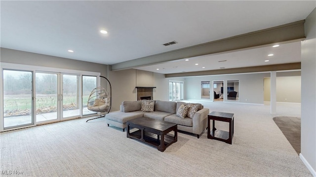 carpeted living room featuring beam ceiling