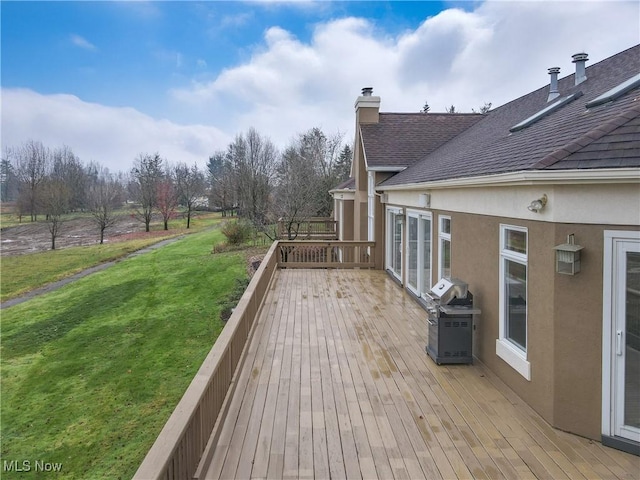 wooden deck featuring a yard and grilling area