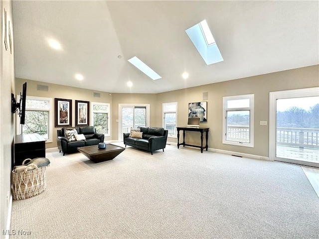 living room featuring lofted ceiling with skylight and light carpet