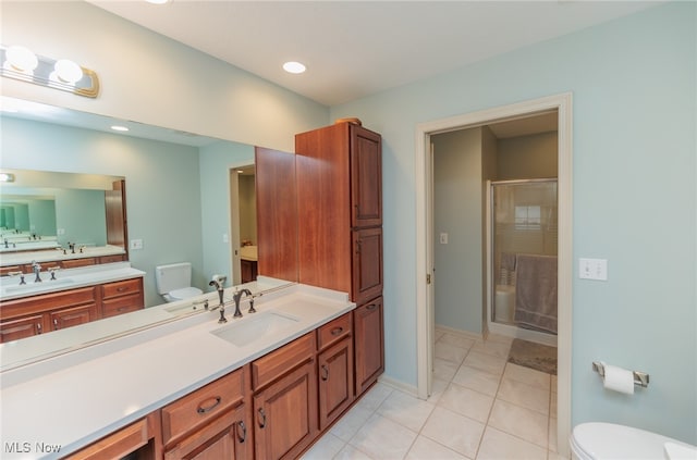 bathroom with toilet, vanity, tile patterned floors, and an enclosed shower