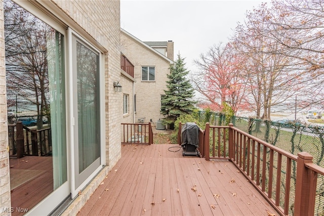 wooden deck featuring area for grilling and cooling unit