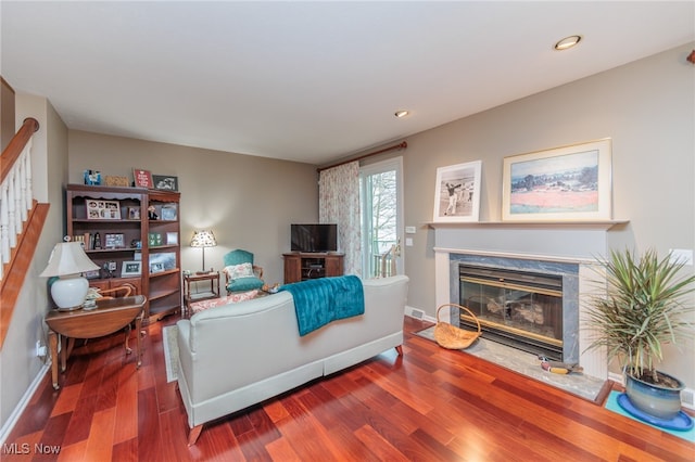 living room with wood-type flooring and a high end fireplace