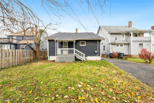 rear view of property featuring a yard