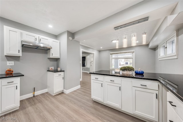 kitchen with white cabinetry, pendant lighting, and light wood-type flooring