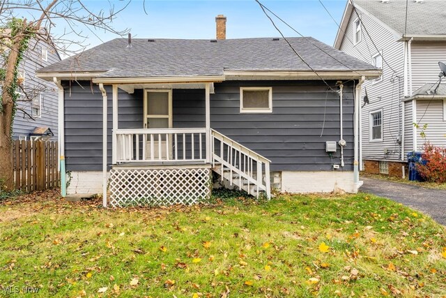 rear view of property featuring a yard