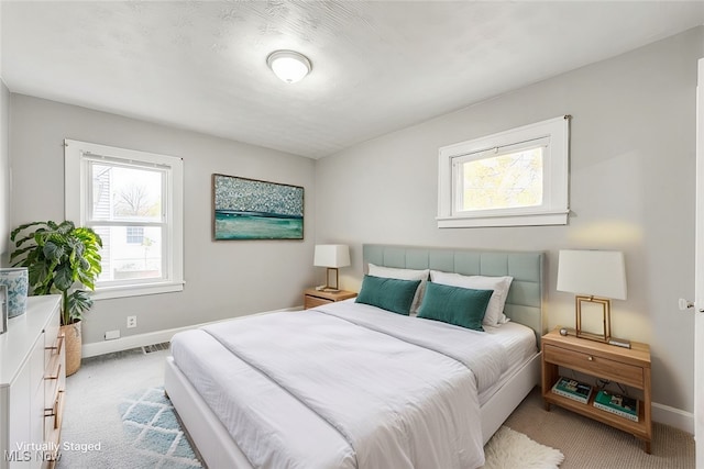 carpeted bedroom with multiple windows