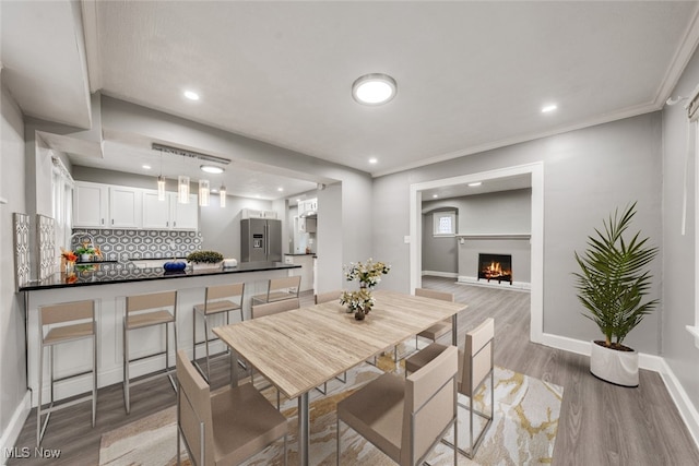 dining room featuring hardwood / wood-style floors and ornamental molding