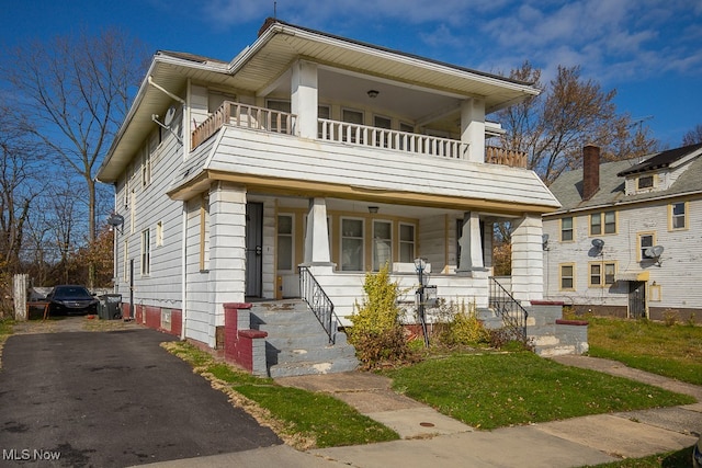 view of front facade with a balcony and covered porch