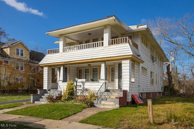 view of front of property with covered porch, a balcony, and a front lawn