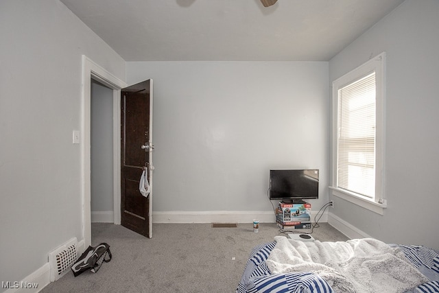 carpeted bedroom featuring ceiling fan and multiple windows