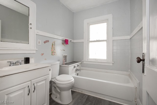 bathroom with a tub to relax in, hardwood / wood-style floors, vanity, and toilet