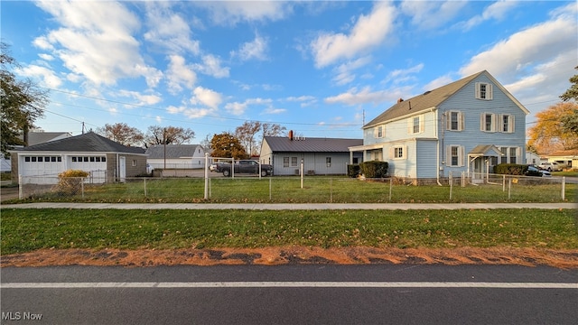 view of front facade featuring a garage, an outbuilding, and a front yard