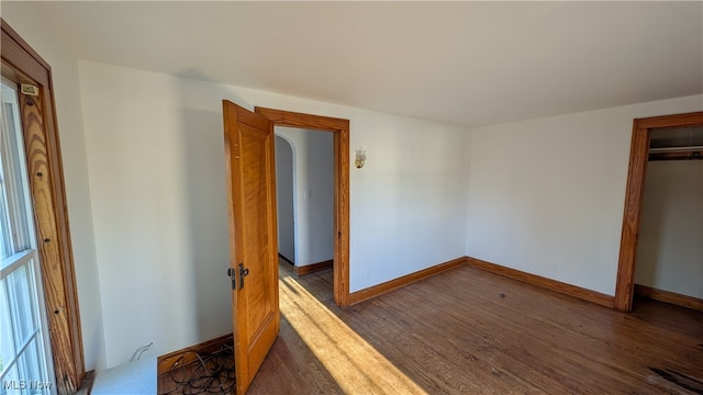 unfurnished bedroom with a closet and dark hardwood / wood-style flooring