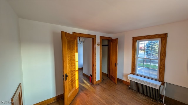 bedroom featuring hardwood / wood-style floors and radiator heating unit