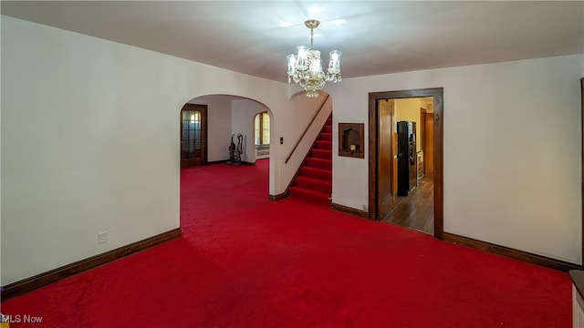 unfurnished room featuring carpet flooring and a notable chandelier