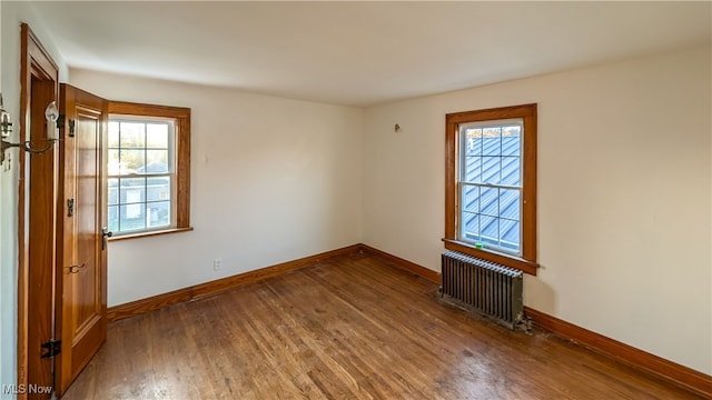 empty room featuring radiator and dark wood-type flooring