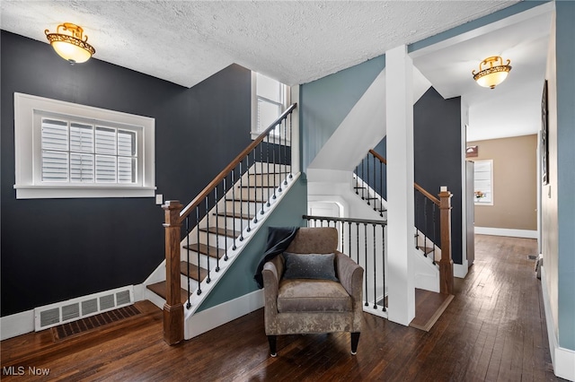 stairway featuring wood-type flooring and a textured ceiling