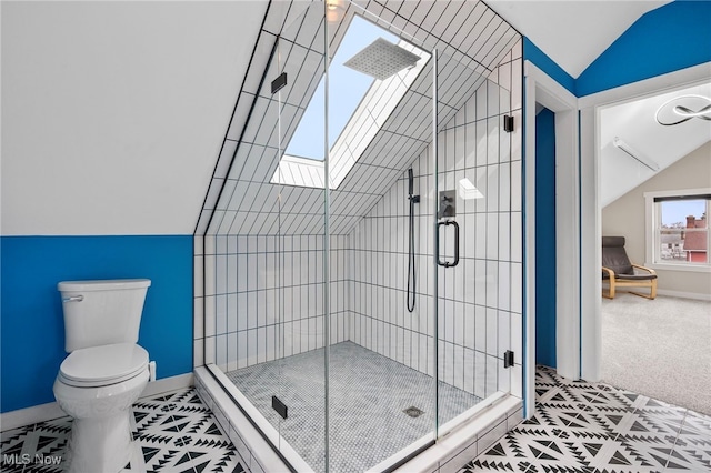 bathroom featuring toilet, a shower with door, and lofted ceiling with skylight