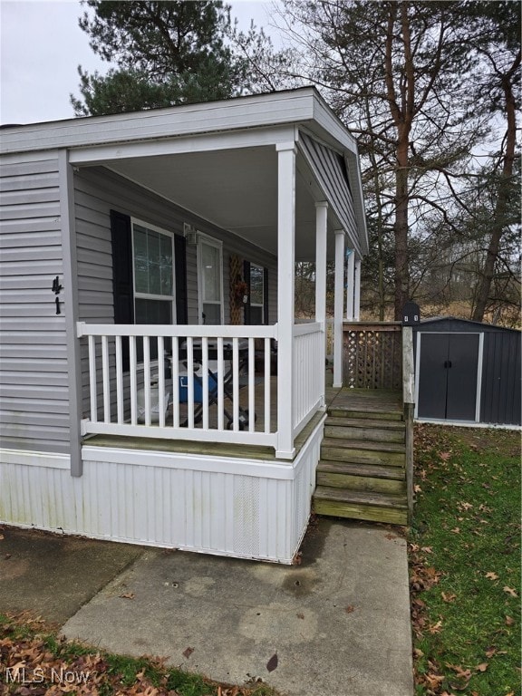 view of side of property with a porch and a shed