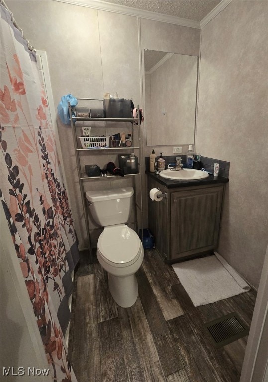 bathroom with hardwood / wood-style floors, vanity, toilet, ornamental molding, and curtained shower