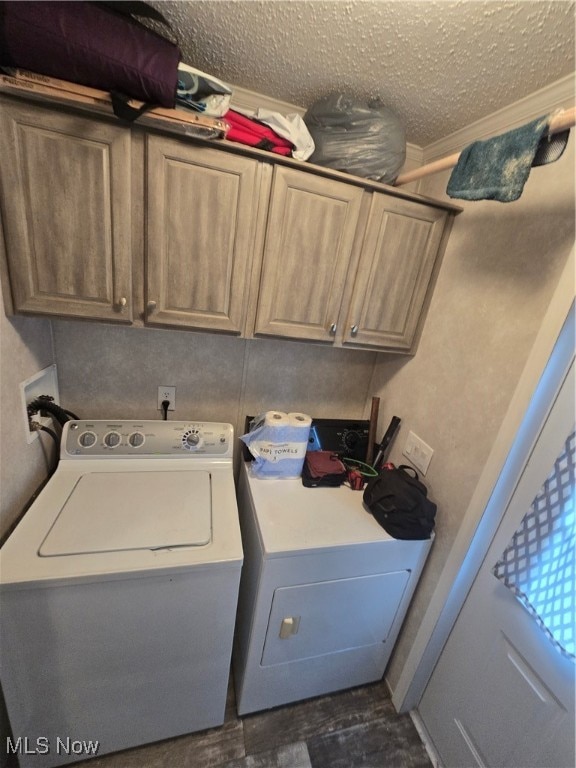 washroom with washing machine and clothes dryer, dark wood-type flooring, cabinets, crown molding, and a textured ceiling