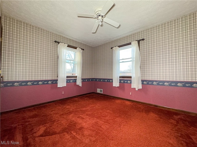 unfurnished room with plenty of natural light, ceiling fan, and a textured ceiling