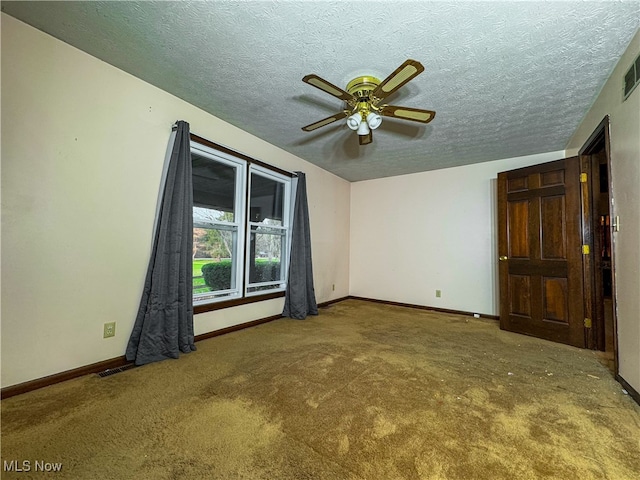 unfurnished room featuring ceiling fan, carpet floors, and a textured ceiling