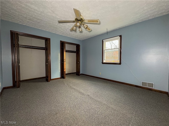 unfurnished bedroom featuring ceiling fan, light colored carpet, and a textured ceiling