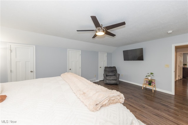 bedroom with a textured ceiling, dark hardwood / wood-style flooring, and ceiling fan