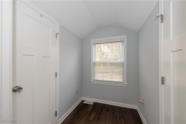 interior space with dark wood-type flooring and vaulted ceiling