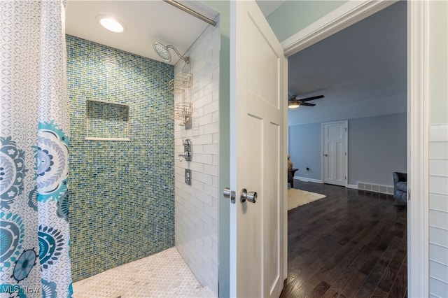 bathroom featuring a tile shower, hardwood / wood-style flooring, and ceiling fan