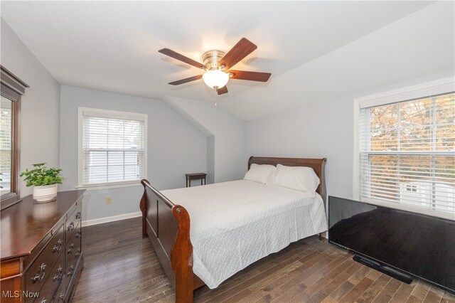 bedroom with ceiling fan, dark wood-type flooring, and lofted ceiling