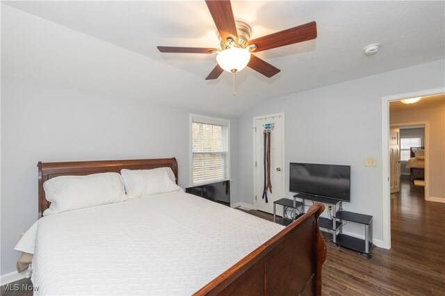 bedroom featuring dark hardwood / wood-style floors, vaulted ceiling, and ceiling fan