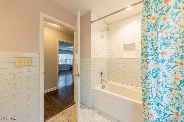 bathroom with shower / bath combo with shower curtain, tile walls, and hardwood / wood-style flooring