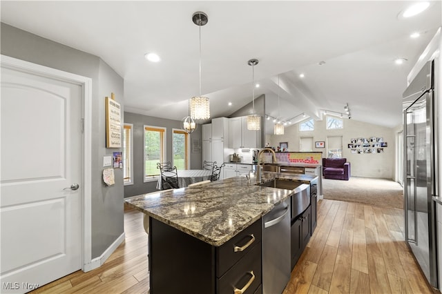 kitchen featuring vaulted ceiling with beams, a center island with sink, pendant lighting, and light hardwood / wood-style flooring