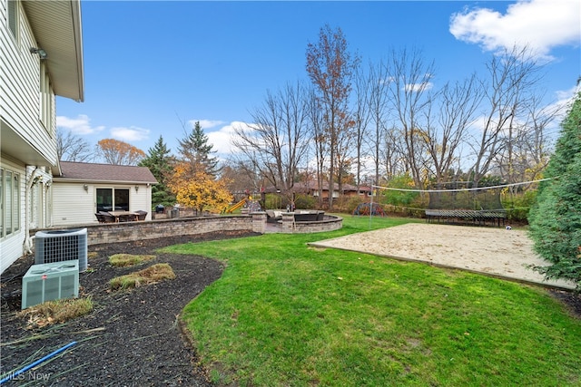 view of yard with volleyball court, central AC, and an outdoor fire pit