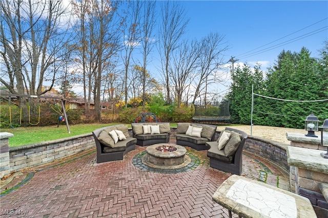 view of patio with an outdoor living space with a fire pit