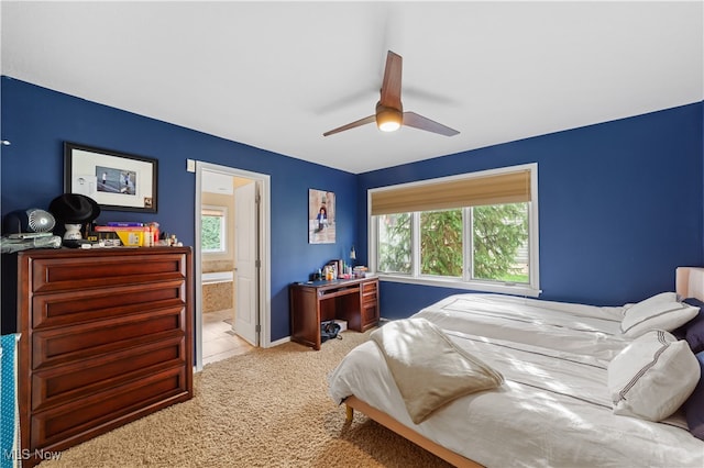 carpeted bedroom featuring ceiling fan and ensuite bath